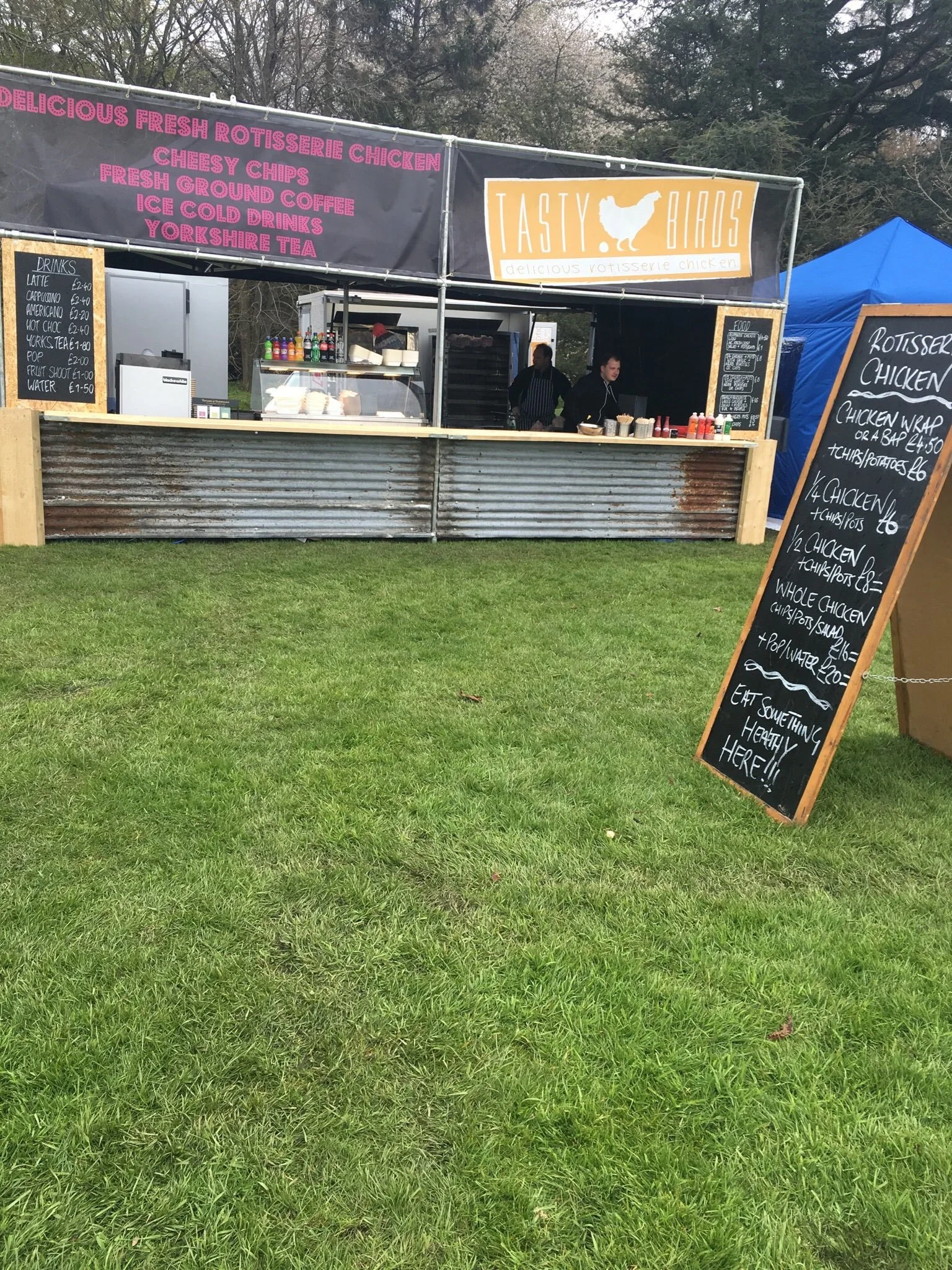 The Tastybirds stall set up at a festival with chalkboard menu
